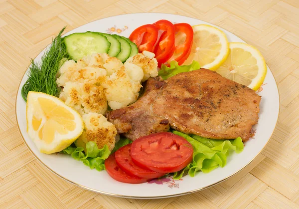 Chuleta de cerdo a la parrilla con guarnición de coliflor y verduras — Foto de Stock