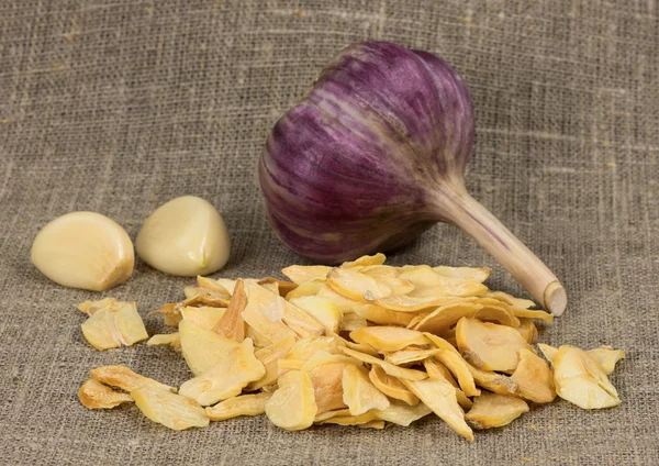 Scattered dried garlic on a background of rough cloth — Stock Photo, Image
