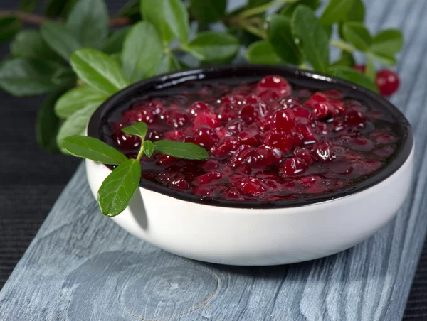 Mermelada de arándanos rojos (fresas) y ramas con hojas — Foto de Stock