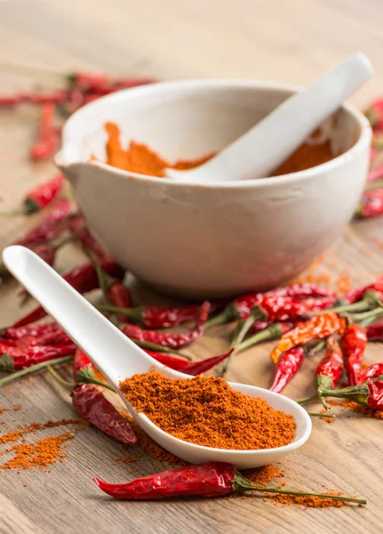 Red hot pepper chili powder in a mortar and pods — Stock Photo, Image