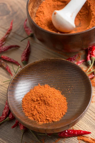 Κόκκινη καυτερή πιπεριά τσίλι σε σκόνη σε ένα γουδί και λοβό — Φωτογραφία Αρχείου