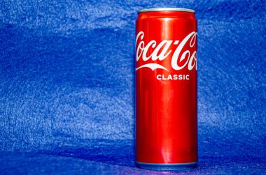 Gomel, Belarus - 30 Eylül 2021: Klasik Coca-Cola, mavi arka planda metal kavanoz kutusu.