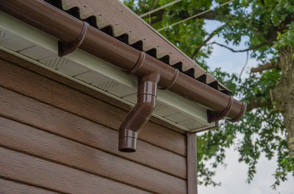 Rännsten med downpipe på taket till ett hus. — Stockfoto