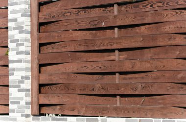 Bahçeli bir apartmanın yanında tuğla direkli dekoratif turuncu çit..