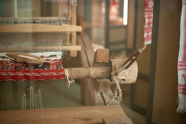 Old loom, spinning machine, rows of white and colored cotton threads