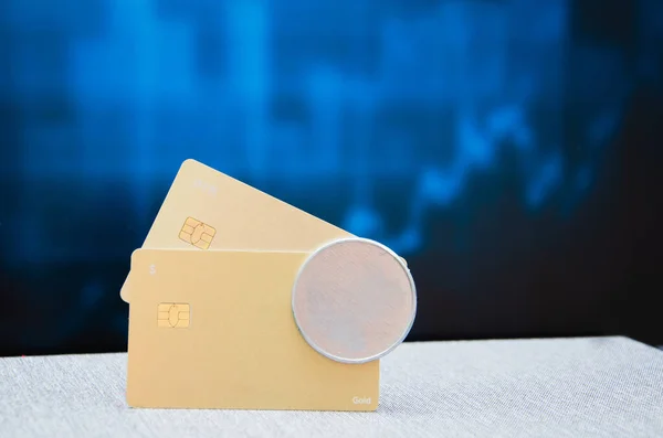 Una mano femenina sostiene una tarjeta bancaria de plástico dorado sobre un fondo de baldosas borrosas. —  Fotos de Stock