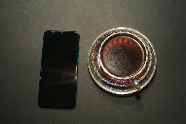 Bir Fincan Kahvenin Üst Görüntüsü Siyah Akıllı Telefondan Izole Edilmiş — Stok fotoğraf