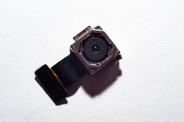 Akıllı telefondan alınan kamera serviste tamir edilmek üzere tabletin üzerinde duruyor.