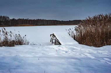 Kış mevsiminde donmuş bir tayga ormanının arasında karla kaplı buz nehrinin dev manzarası..
