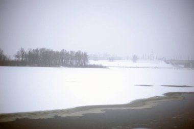 Kış mevsiminde donmuş bir tayga ormanının arasında karla kaplı buz nehrinin dev manzarası..