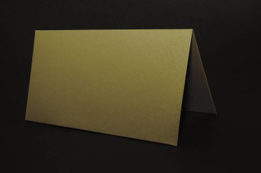 Siyah düz bir arka planda altın bir zarf, lüks bir şirket kimliği ve üzerinde 