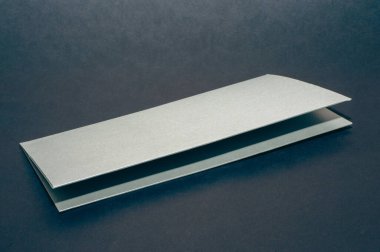 Siyah düz arka planda gri, gümüş bir zarf. Lüks bir şirket kimliği ve üzerinde 