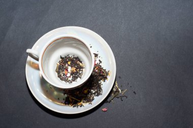 Siyah arkaplanda yeşil yapraklı kuru çay.