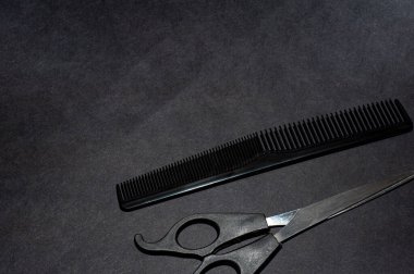 Profesyonel berber makasları, siyah arka planda saç kesimi. Kuaför salonu konsepti, kuaför seti. Saç kesimi aksesuarları.