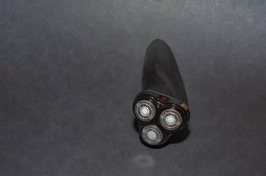 Siyah arka plandaki erkekler için parlak siyah elektrikli tıraş makinesi.
