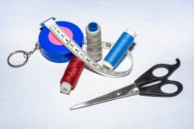 Dikiş dikişleri. Bir makara iplik, iğne, düğme, makas ve mezura. Seçici odak