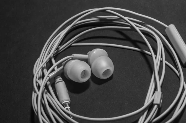 Fehér Sodrott Vezetékes Fejhallgató Egy Monokromatikus Fekete Felületen Közelkép Fülhallgató — Stock Fotó