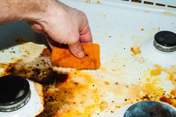 Dirty stove with food leftovers. Unclean gas kitchen cooktop with greasy spots, old fat stains, fry spots and oil splatters.