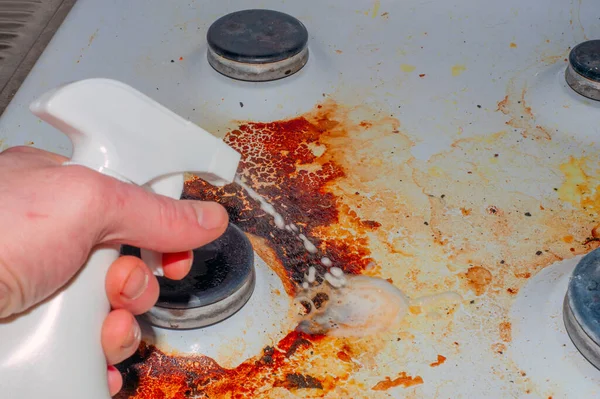 Dirty stove with food leftovers. Unclean gas kitchen cooktop with greasy spots, old fat stains, fry spots and oil splatters.