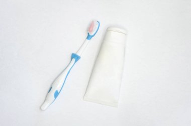 Yetişkinler ve çocuklar için diş fırçaları ve izole edilmiş beyaz arka planda bir tüp macun. Metin eklenecek bir yer ile