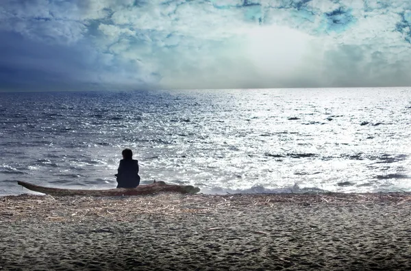 Vrouw reflecteren op het strand Stockafbeelding