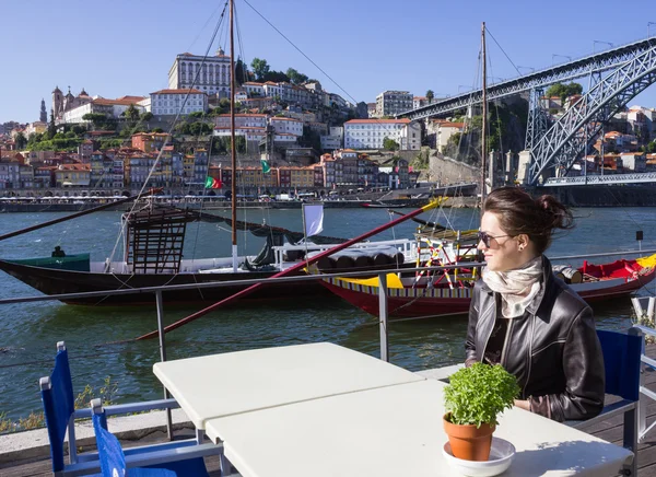 Mujer joven sentada en un café a orillas del río, Oporto , — Foto de Stock