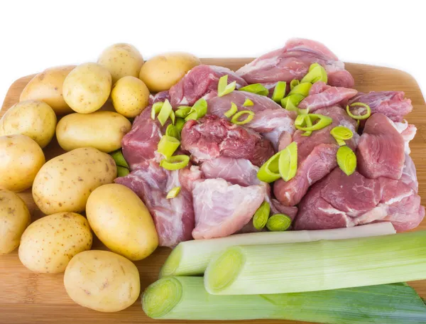 Trozos de carne y patatas en una tabla de picar —  Fotos de Stock