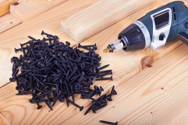Screws and a screwdriver on a boards — Stock Photo, Image