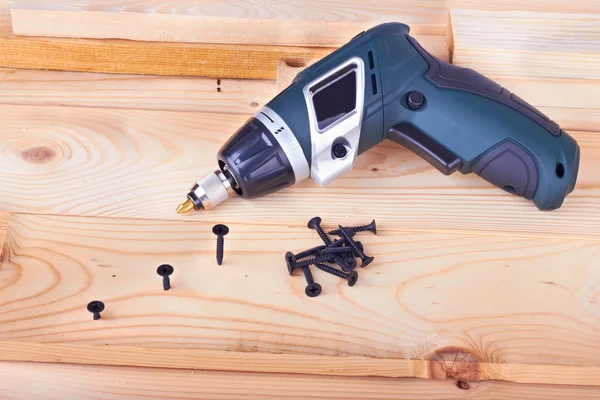 Screws and a screwdriver on a pine boards — Stock Photo, Image