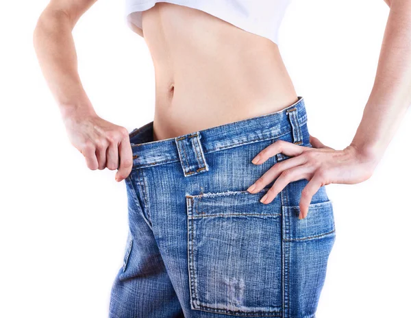 A young slim woman in oversized pair of blue jeans — Stock Photo, Image