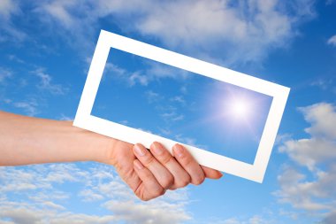 Mavi gökyüzü kadın eli çerçevede beyaz kağıt