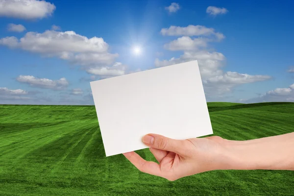 Blank Sign in Female hand Over Grass Field — Stock Photo, Image