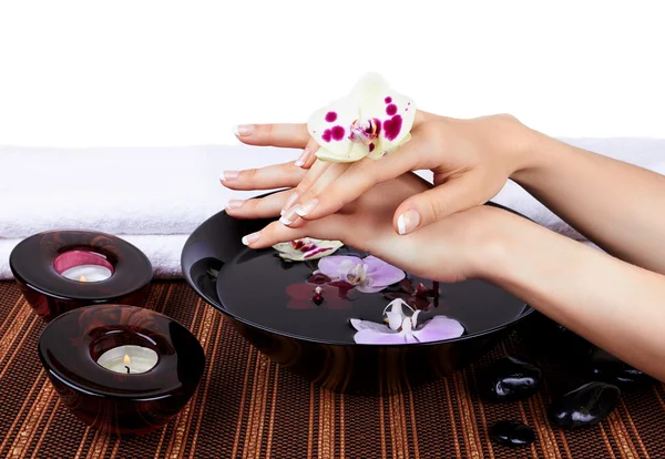 Woman's hands with orchids and bowl of water — Stock Photo, Image