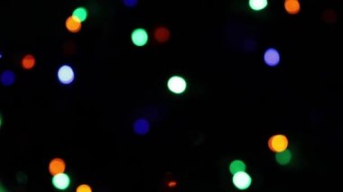 Yılbaşı arifesi ve yılbaşı arifesinde, Noel ağacının üzerinde çok renkli bir çelenk. Parlak renkli ışıklar, bokeh deseni. Neşeli renkli arkaplan. 