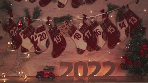 圣诞贺卡 上面有2022年新年的花环灯 将日历袜和装有礼物的盒子放在壁炉上 圣诞和新年前夕 装饰住房和假日准备工作 — 图库视频影像