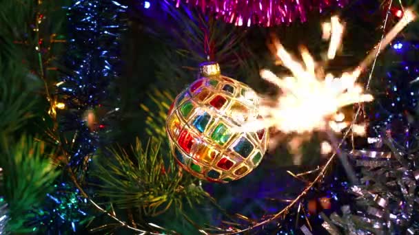 光沢のあるガーランドと燃える輝きの間のクリスマスツリー上の多色ステンドグラスのクリスタルボール クリスマスと新年の気分 ツリー上のガーランドや輝きの輝くライト — ストック動画