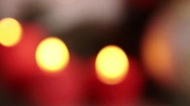 Bulanık. Şöminenin üzerindeki kırmızı mumlar karanlıkta yanıyor. Sevgililer Günü 'nde mum yakmak. Noel ışıkları bulanık. Kırmızı mumlar gece Bokeh 'te yanar. Aşk ilanı. Anma ışıkları