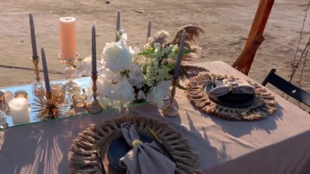 一个节庆的餐桌 上面装饰着美丽的菜肴和花朵 以备在多风的天气里在海滨举行婚礼 漂亮地摆好桌子庆祝情人节 宣布爱情 举行婚礼 庆祝结婚周年 — 图库视频影像