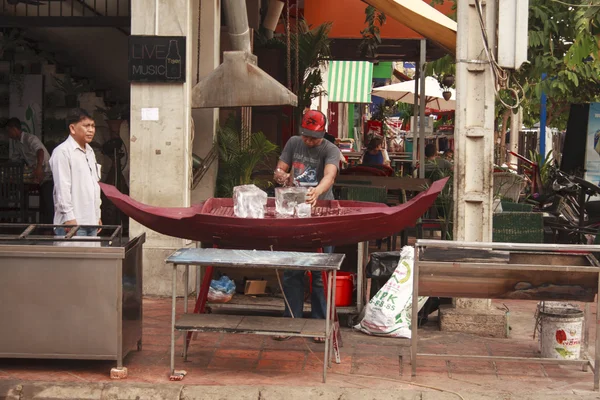 Cambodian man cuts ice on a street — Stock Photo, Image