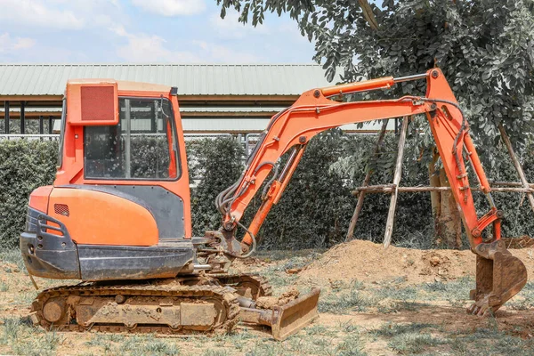 The orange mini  backhoe stop in Construction site