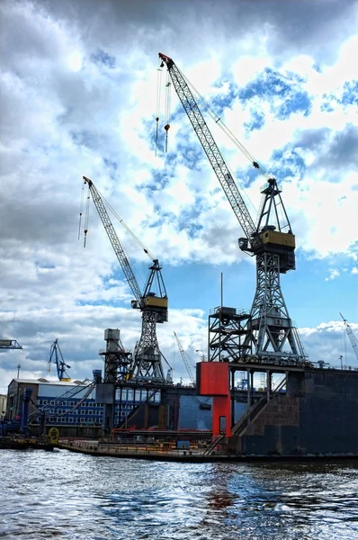 Kranar som silhuetter i Hamburg hamn — Stockfoto