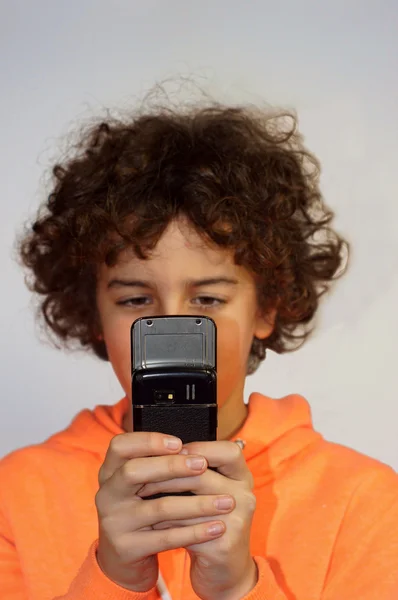 Ein Junge sendet eine Nachricht auf seinem Handy — Stockfoto