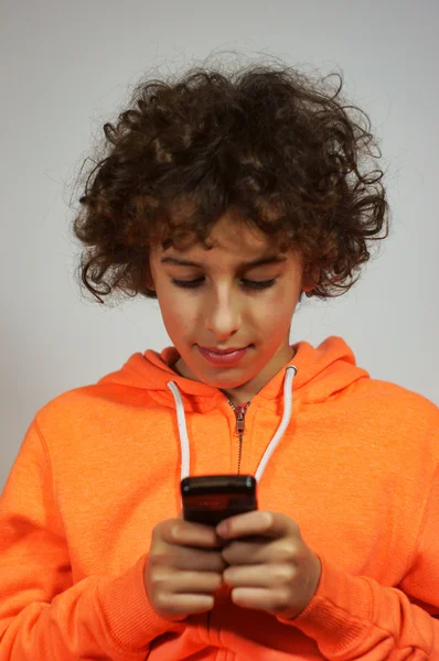 Un garçon envoie un message sur son téléphone portable — Photo