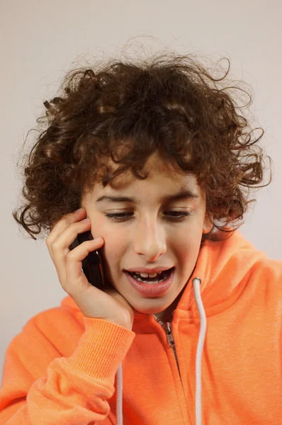 A young boy is chatting with his friends on the phone — Stock Photo, Image