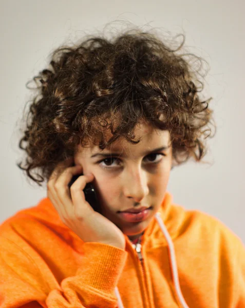 A young boy is speaking on the mobile phone — Stock Photo, Image