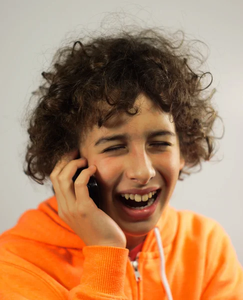 Een jonge jongen is praten over een telefoon — Stockfoto