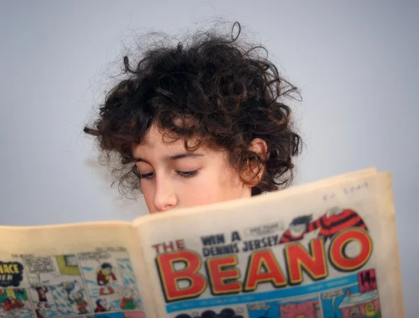 genç çocuk bir çizgi roman okuyor