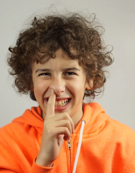 Młody chłopak jest zbieranie nos z bezczelny uśmiech — Zdjęcie stockowe