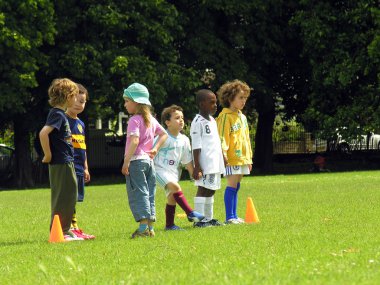 Çocuklar parkta futbol oynuyor.