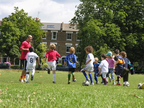 Kids playing football in the park — Stock Photo, Image